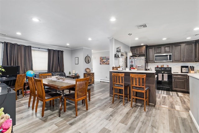 dining area featuring crown molding, a baseboard heating unit, and light wood-type flooring