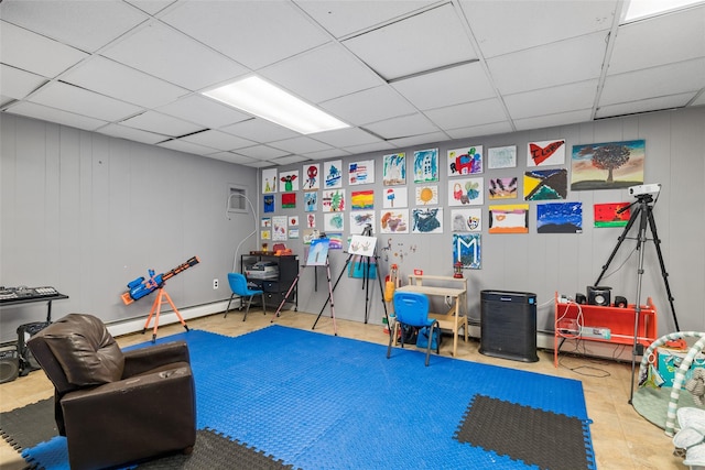 recreation room with a drop ceiling, a baseboard radiator, and tile patterned floors