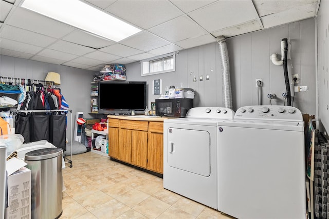 laundry area featuring light tile patterned floors, washing machine and dryer, and cabinets