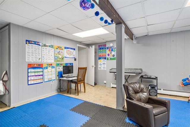 office area featuring a paneled ceiling and a baseboard heating unit