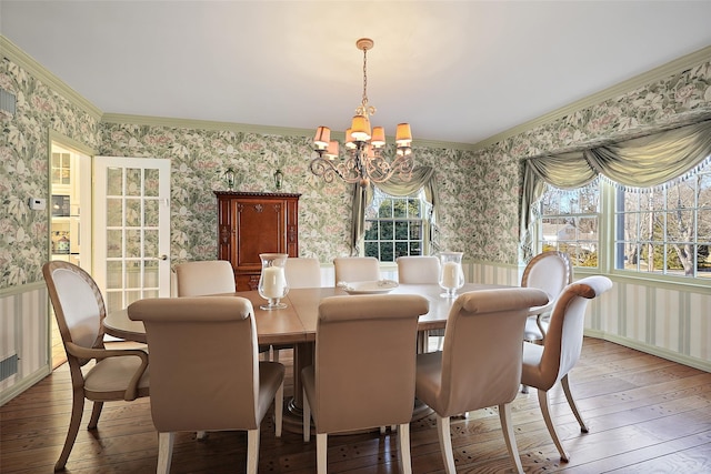 dining area with crown molding, hardwood / wood-style floors, and a notable chandelier