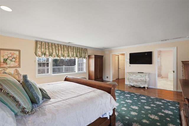 bedroom with ornamental molding, wood-type flooring, and ensuite bathroom