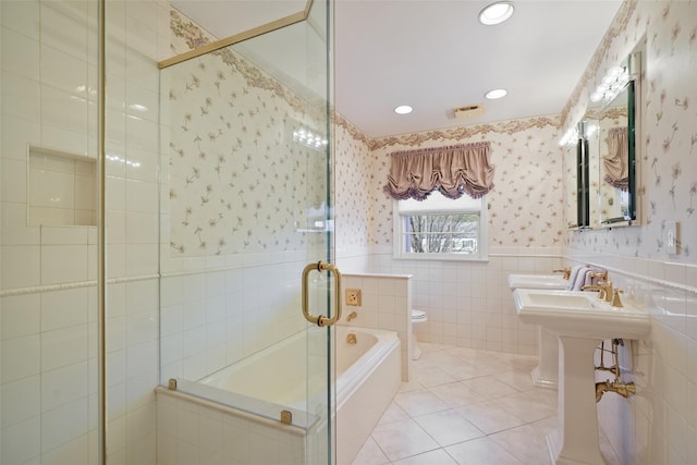 bathroom featuring tile patterned floors, toilet, independent shower and bath, and tile walls