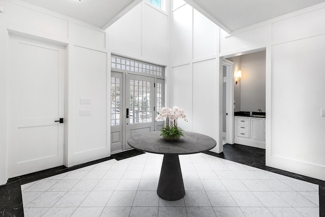 tiled foyer with french doors and a high ceiling