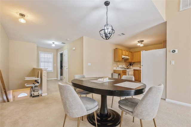 carpeted dining area with an inviting chandelier