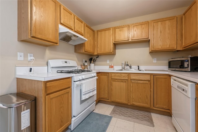 kitchen featuring light tile patterned flooring, white appliances, and sink