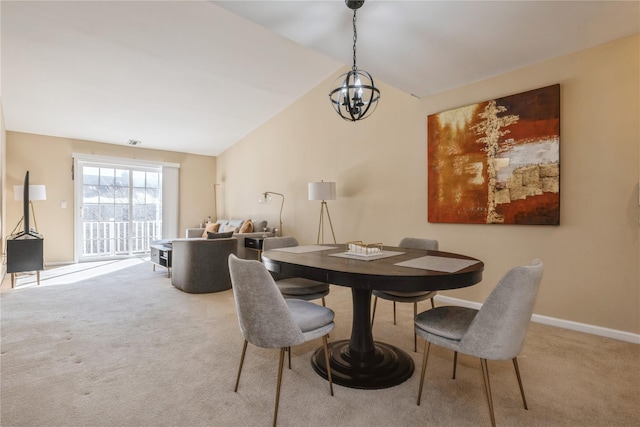 dining area with a notable chandelier, vaulted ceiling, and light colored carpet