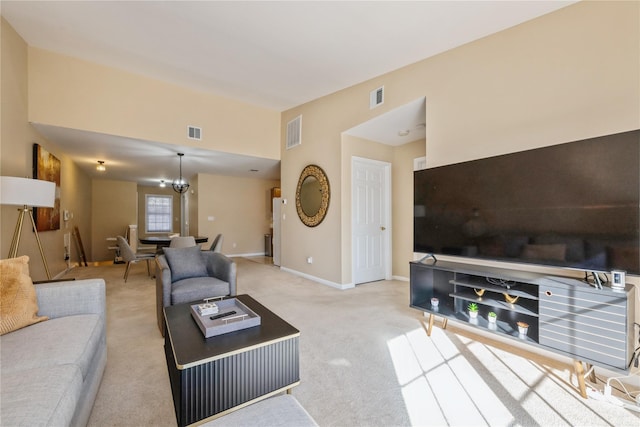 carpeted living room featuring a chandelier