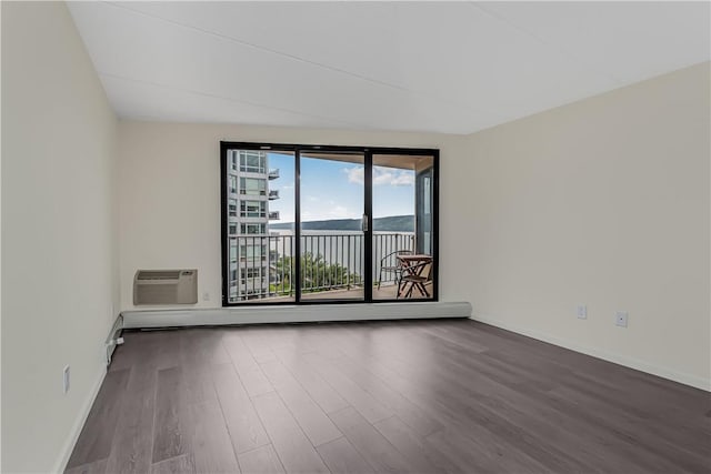 empty room with dark hardwood / wood-style floors and a wall unit AC