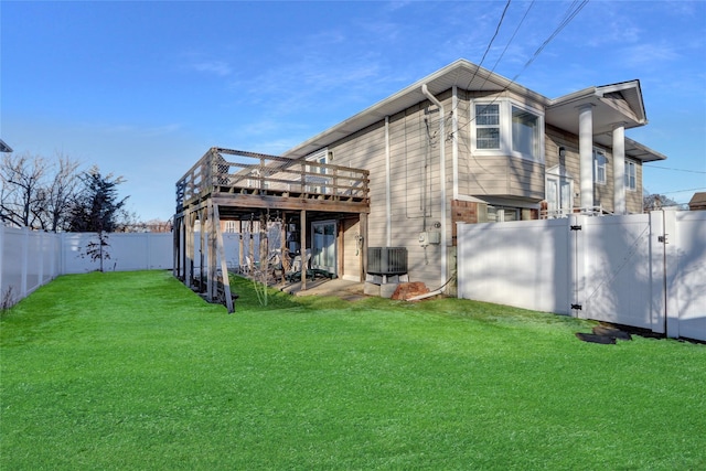 back of house featuring a deck, a lawn, and central air condition unit