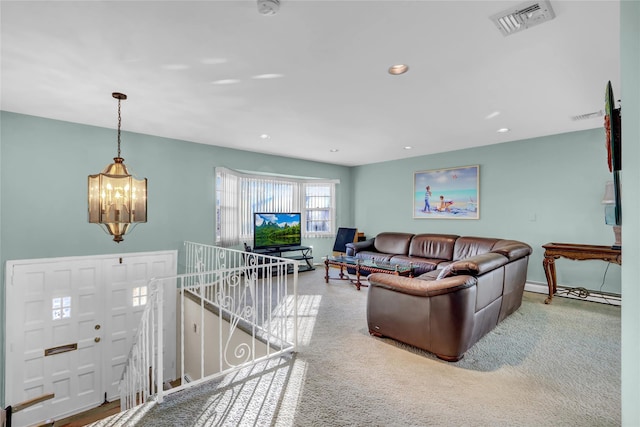 living room featuring a notable chandelier and carpet flooring