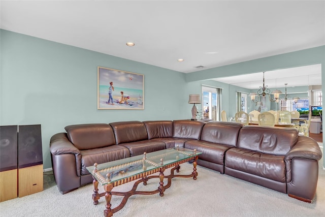 carpeted living room with an inviting chandelier and a wealth of natural light