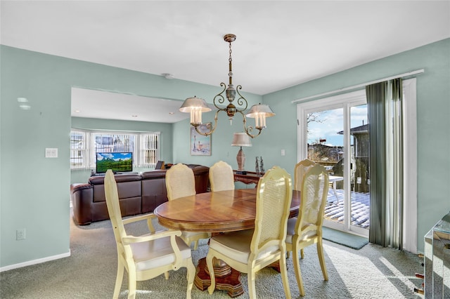 carpeted dining room featuring plenty of natural light and a chandelier