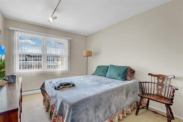 carpeted bedroom featuring a baseboard radiator and rail lighting