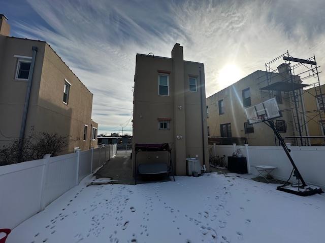 view of snow covered back of property