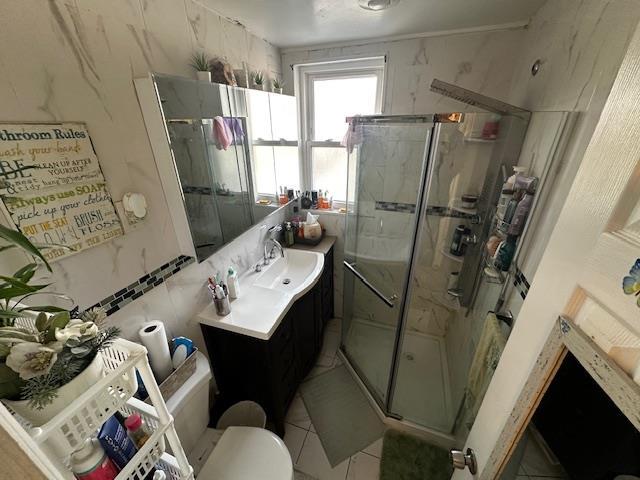 bathroom featuring vanity, an enclosed shower, and toilet