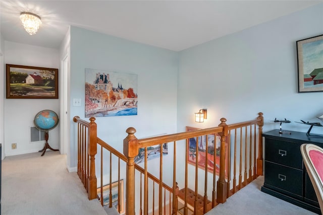 hall featuring a chandelier and light carpet