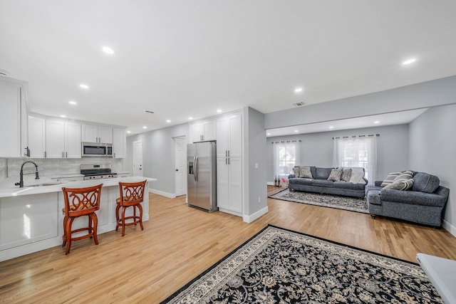 living room with sink and light wood-type flooring