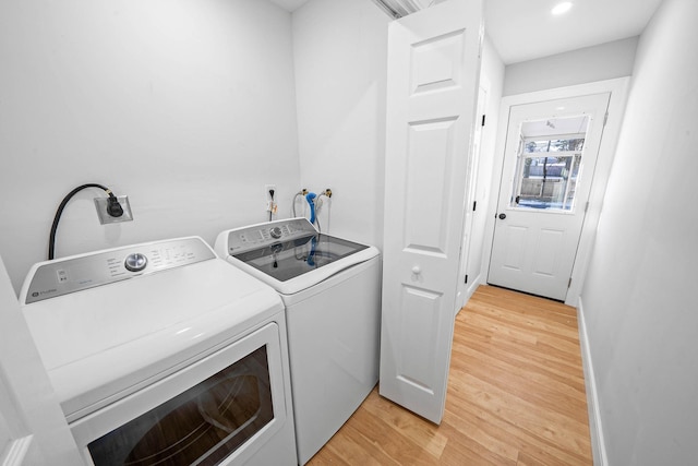 clothes washing area featuring hardwood / wood-style flooring and washing machine and clothes dryer