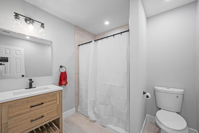 bathroom featuring vanity, hardwood / wood-style floors, walk in shower, and toilet