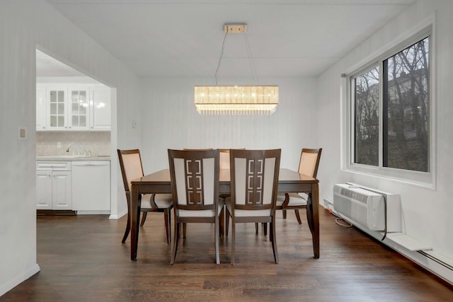 dining space featuring dark hardwood / wood-style flooring, a wall mounted air conditioner, and a chandelier