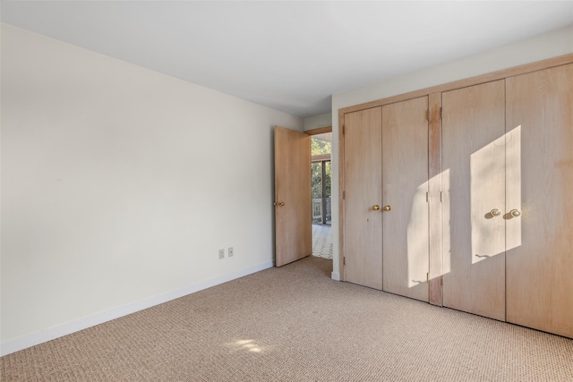 unfurnished bedroom with light carpet and a closet