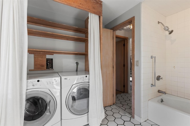 laundry area with washer and dryer and light tile patterned floors