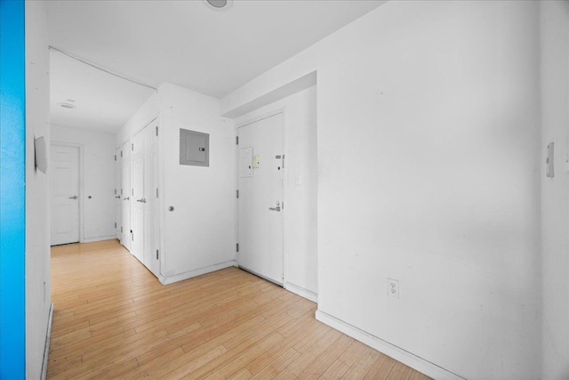 corridor featuring electric panel and light hardwood / wood-style flooring