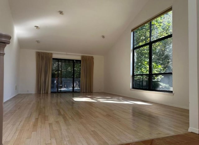 unfurnished living room with lofted ceiling and light wood-type flooring