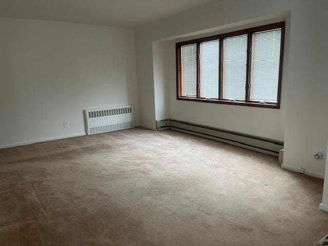 unfurnished room featuring carpet flooring, radiator, and a baseboard heating unit