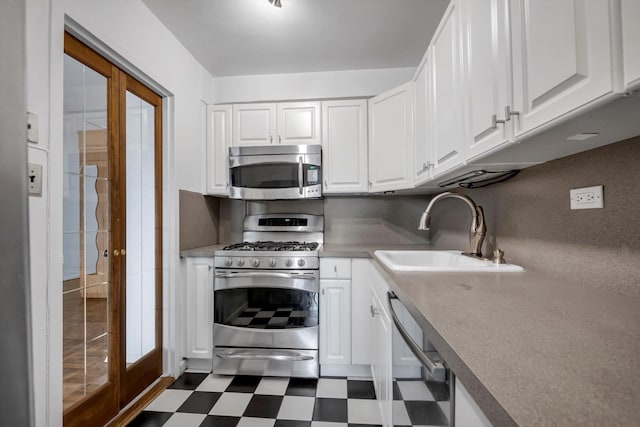 kitchen with white cabinetry, sink, stainless steel appliances, and french doors