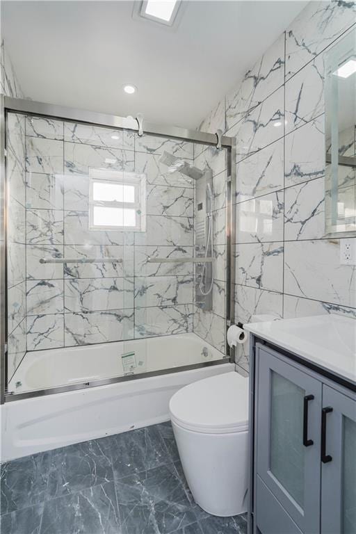 full bathroom featuring enclosed tub / shower combo, vanity, toilet, and tile walls