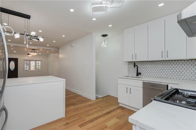 kitchen featuring light hardwood / wood-style flooring, sink, hanging light fixtures, and white cabinets