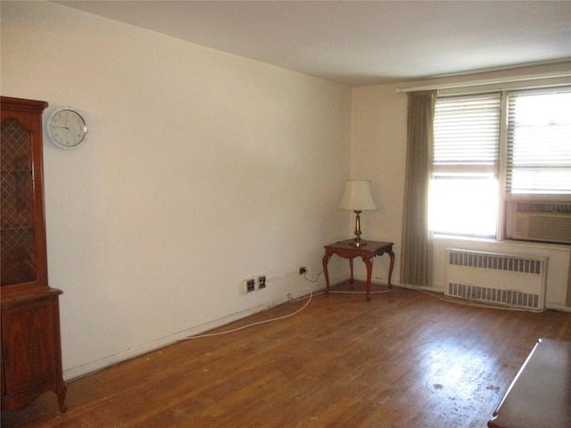 unfurnished room with dark hardwood / wood-style flooring, cooling unit, and radiator heating unit