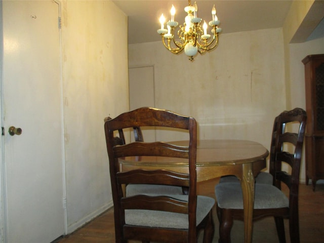 dining space featuring dark wood-type flooring and a chandelier