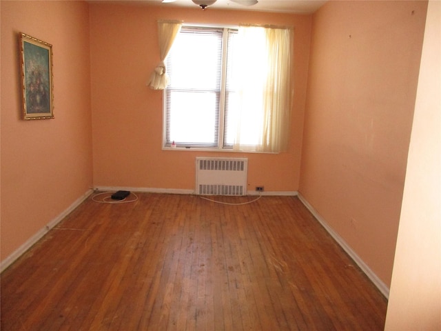 unfurnished room featuring radiator and wood-type flooring