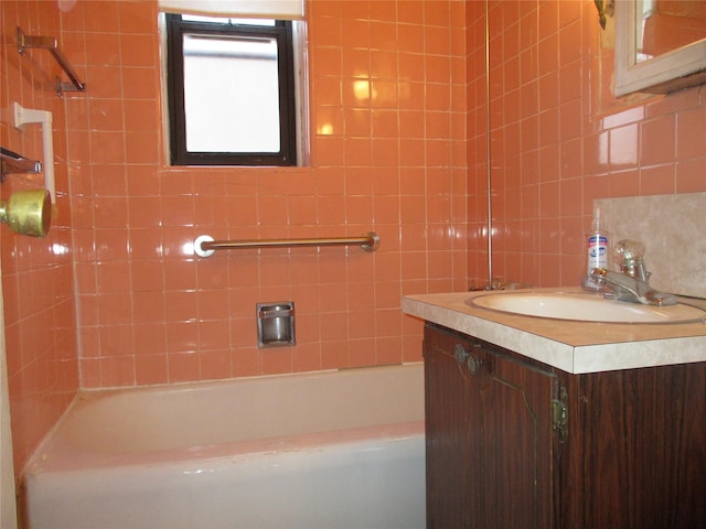 bathroom with tile walls, vanity, backsplash, and shower / tub combination