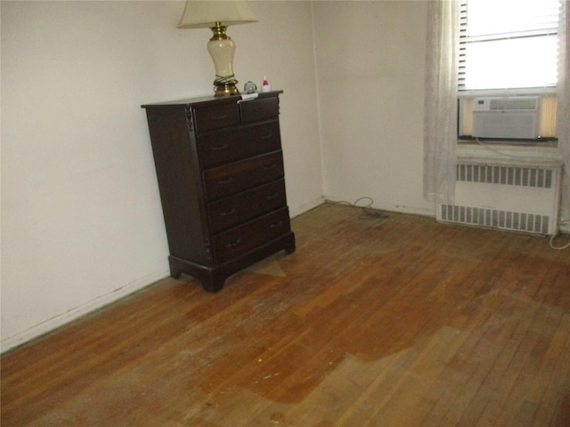 bedroom featuring cooling unit, radiator, and dark hardwood / wood-style floors