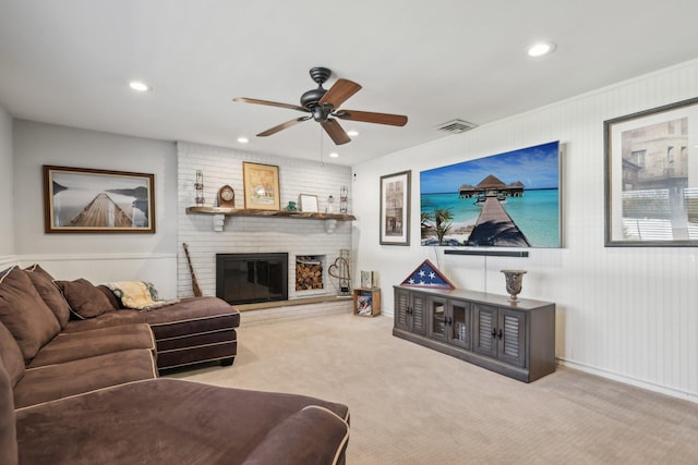 carpeted living room featuring ceiling fan and a brick fireplace