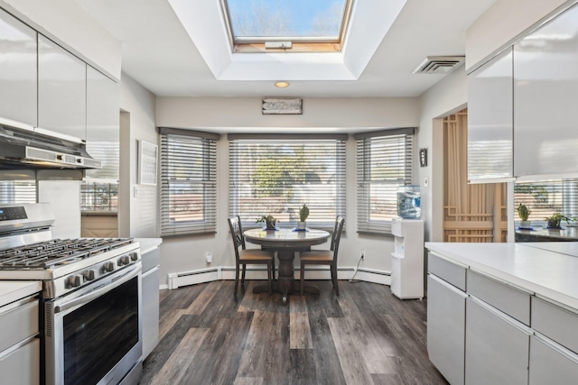 kitchen featuring stainless steel gas stove, a skylight, a baseboard heating unit, dark hardwood / wood-style flooring, and white cabinets