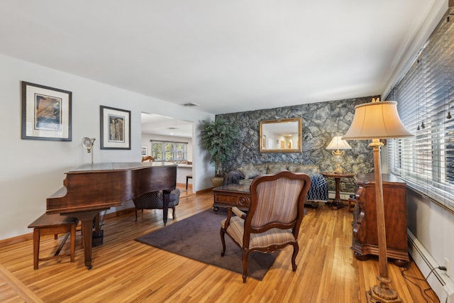 sitting room with a baseboard radiator and light wood-type flooring