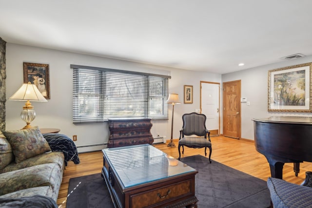 living room featuring a baseboard heating unit and light hardwood / wood-style floors