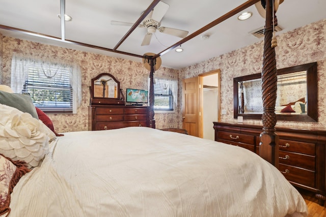 bedroom with ceiling fan and multiple windows