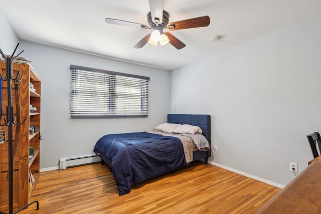 bedroom featuring light hardwood / wood-style flooring, a baseboard radiator, and ceiling fan