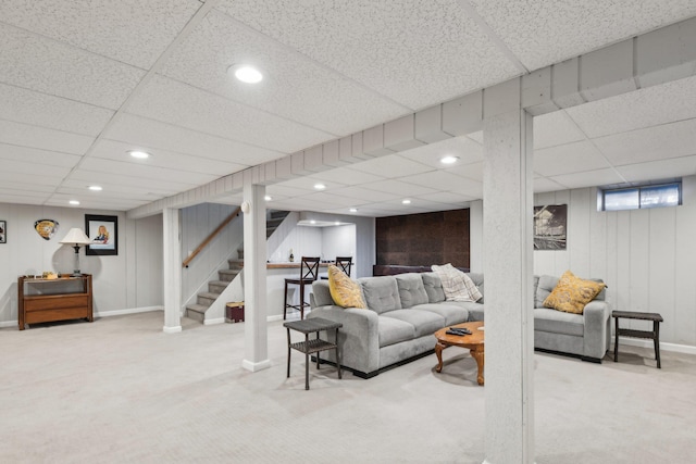 living room featuring a paneled ceiling and carpet