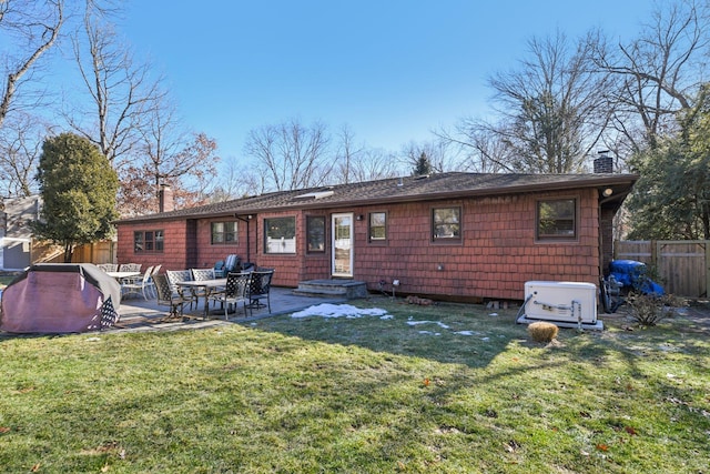 back of house featuring a patio area and a lawn