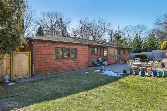 rear view of property with a yard and a patio