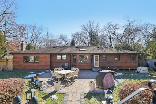 back of property with a patio and a lawn