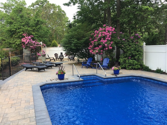 view of pool featuring a patio and an outdoor fire pit