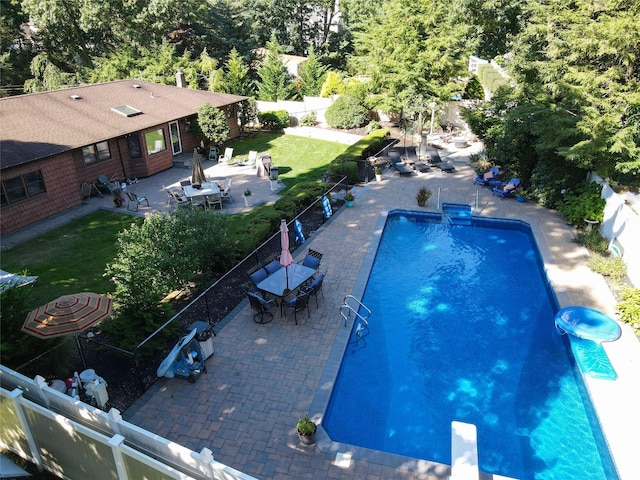 view of pool featuring a patio, a diving board, and a lawn